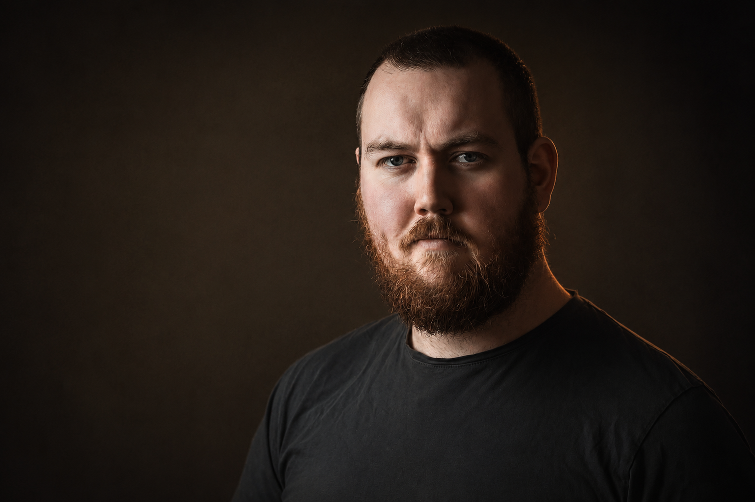 Portrett av fotograf Vegard Kristoffersen mot mørk bakgrunn